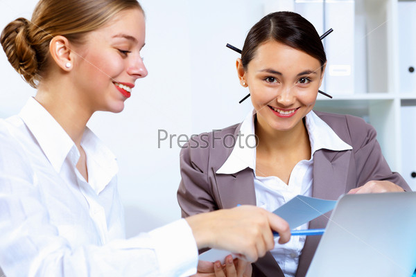 Young women in business wear working in office, stock photo