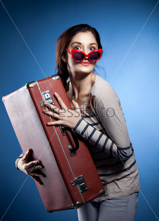 Portrait of the lovely woman with suitcase in retro style