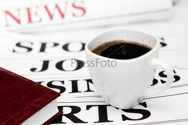 An image of a cup of coffee and a newspaper on the table, stock photo