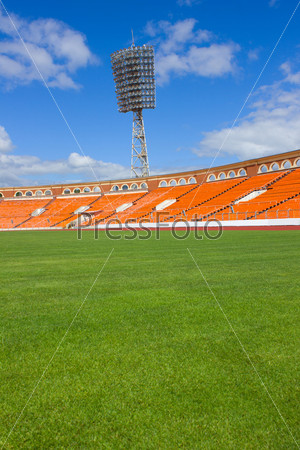 football field with light stand and orange seats