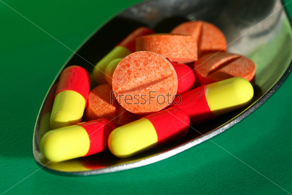 A pile of pills on iron spoon, stock photo