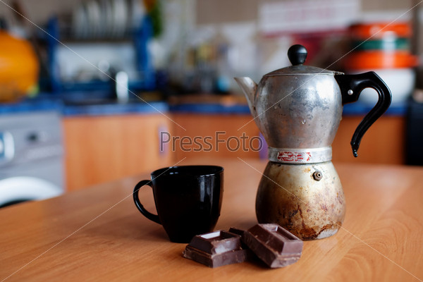 Кофеварка с чашкой и шоколадом