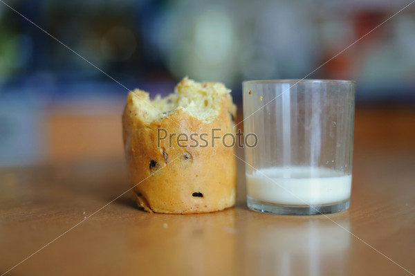 An image of a cake and a glass with some milk on a table, stock photo