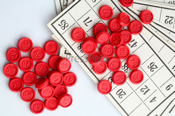 An image of red bingo game chips on card