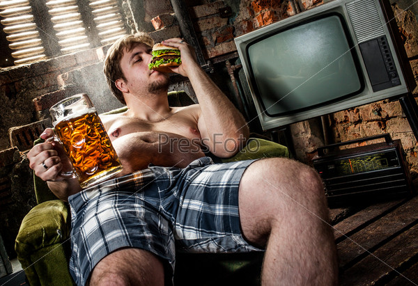 fat man eating hamburger seated on armchair