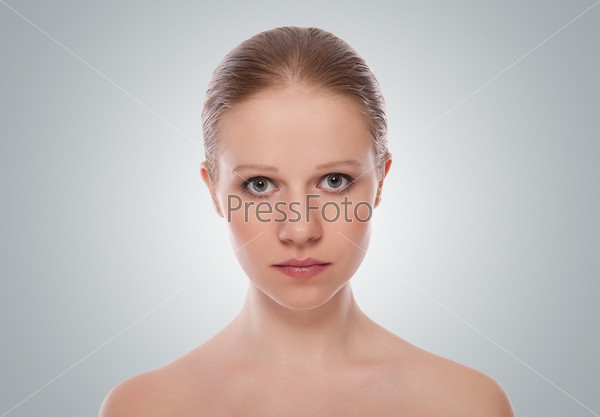 Skin care portrait of a beautiful young woman on a gray background, stock photo
