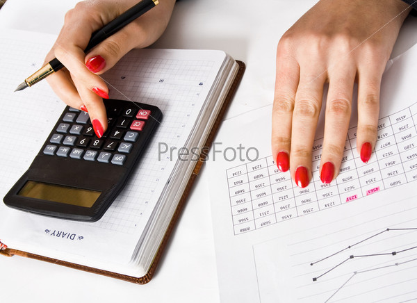 Woman holding a pen counts on the calculator