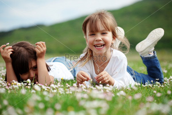 Счастливые дети играют на зеленом поле