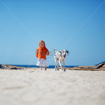 Child walking alone with her lovely dog at beach