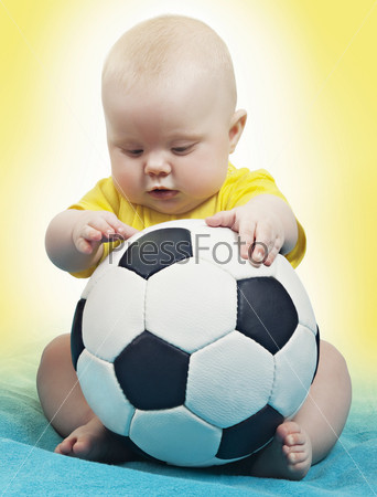 Маленький ребенок с футбольным мячом на желто-синем фоне