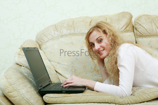 Девушка с ноутбуком на диване