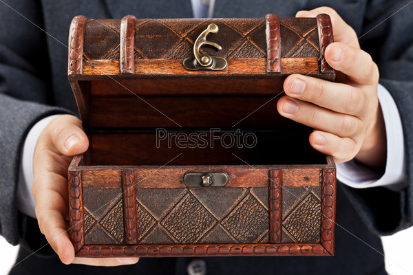 Business man hand holding old antique brown wood treasure chest or box white isolated