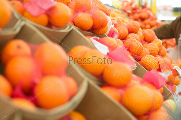 Variety of oranges in boxes in supermarket