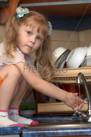 Girl helping her mother to wash dishes