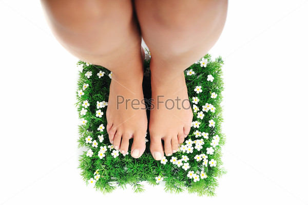 woman legs walking on small peace of green grass isolated on\
white representing last oasis concept