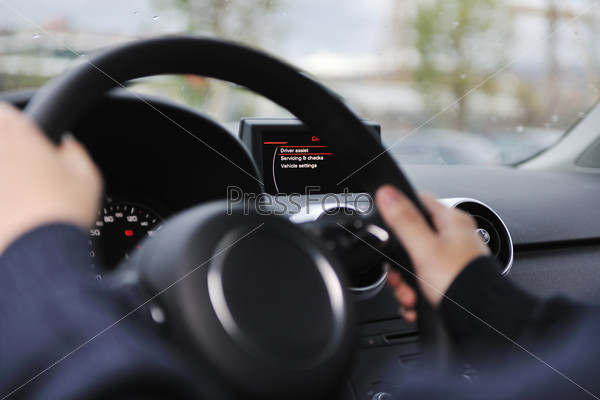 Young man using new car navigation and onboard vehicle transport system, stock photo