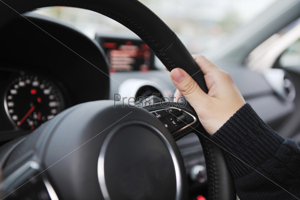 Young man using new car navigation and onboard vehicle transport system, stock photo