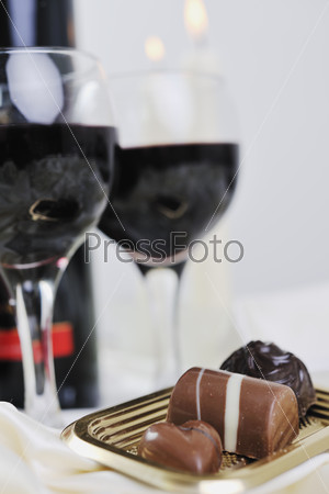 Роскошные сладкие пралине и шоколад с бокалами вина
