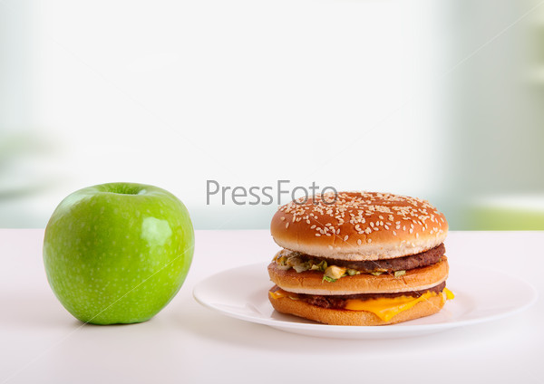 choice of healthy and unhealthy food. Diet concept: green apple and hamburger