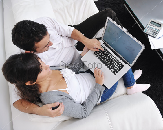 Молодая пара с ноутбуком в домашней обстановке