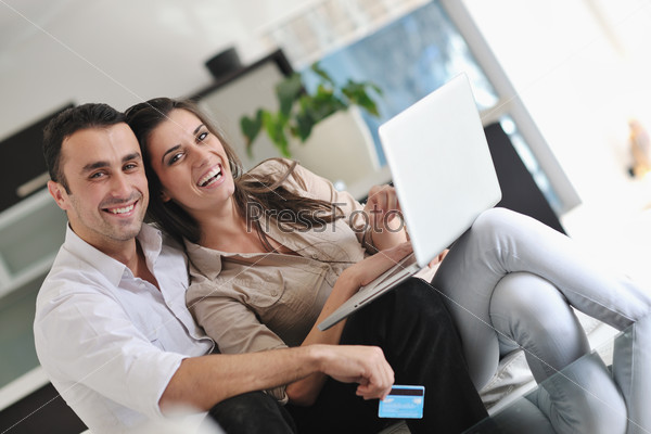 Joyful couple relax and work on laptop computer at modern home