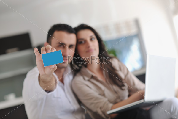 Couple work on laptop computer at modern home