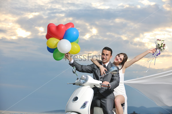 wedding sce of bride and groom just married couple on the beach ride white scooter and have fun