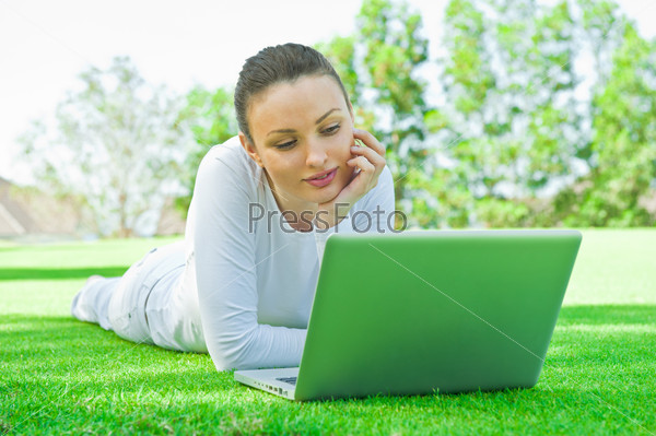 Portrait of smiling woman chatting with her friends or family using laptop with wireless internet connection