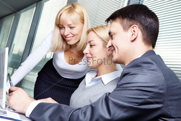 Three business people discussing project at meeting, stock photo