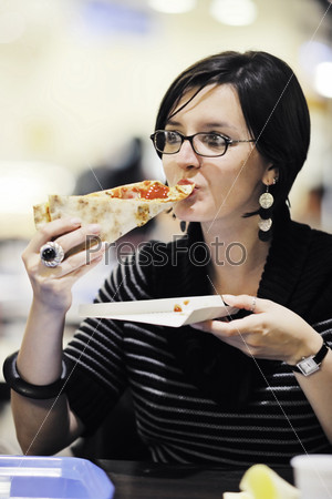 Молодая женщина ест пиццу