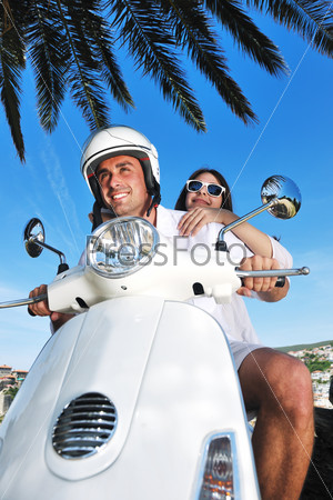 Счастливая молодая пара на скутере летом