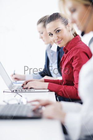 Молодые женщины с ноутбуком и гарнитурой работают в офисе