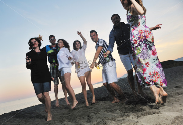 Group of young people enjoy summer party at the beach
