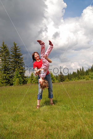 Девушка играет с девочкой на открытом воздухе