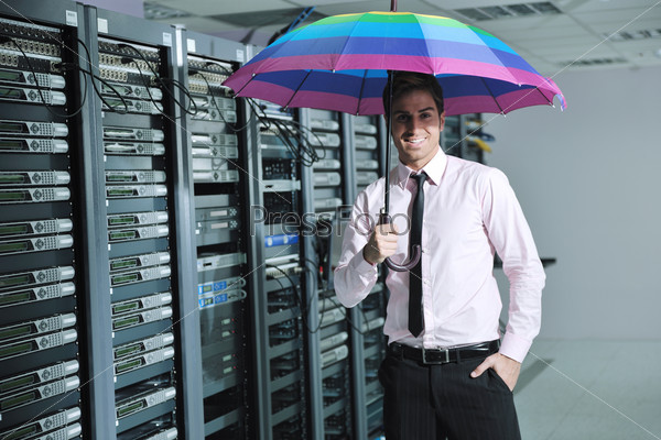 Инженер в серверной комнате с ярким зонтиком в руке. Концепция антивирусной защиты