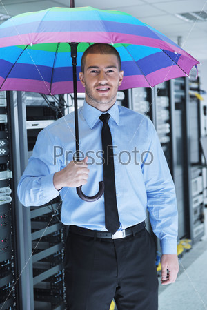 young handsome business man  engineer in  businessman hold  rainbow colored umbrella in server datacenter room  and representing security and antivirus sofware protection concept