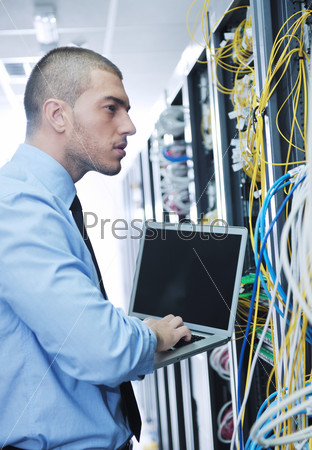 businessman with laptop in network server room