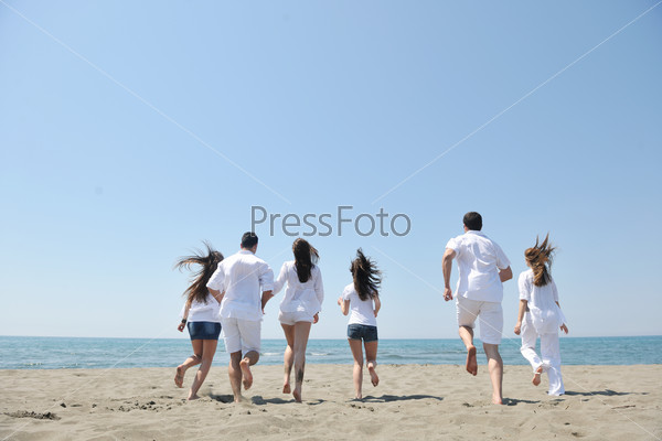 Happy people group have fun run and jump on beach beautiful sand beach, stock photo