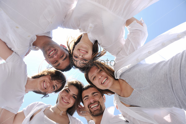 Group of happy young people in circle at beach  have fun and smile