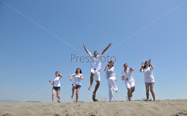 Группа счастливых молодых людей на морском пляже
