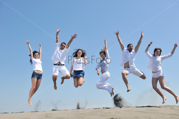 Группа счастливых молодых людей на морском пляже