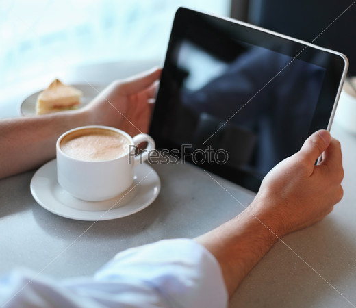 Man holding tablet computer in cafe