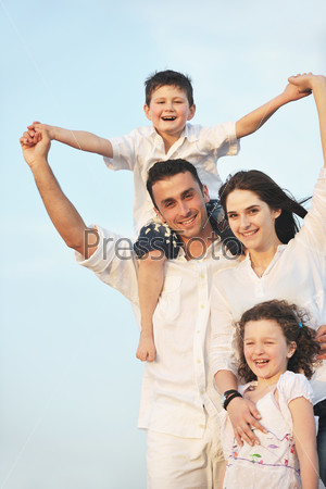 Счастливая молодая семья отдыхает на пляже