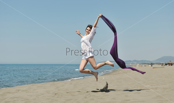 Счастливая молодая женщина отдыхает на пляже на рассвете