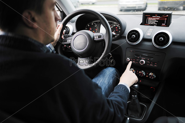 Молодой человек за рулем автомобиля с новой системой навигации