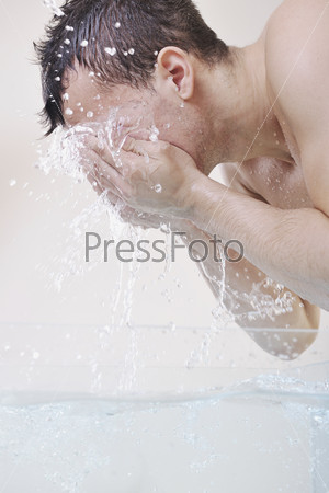 young man washing face with clean water and representing hygiene and mans beauty concept