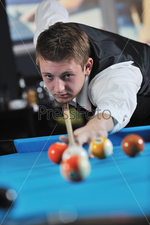 Молодой человек играет в бильярд