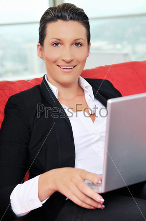 young business woman working on laptop at home in comfort bright apartment