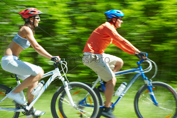 Image in motion of two bicyclists riding on country road