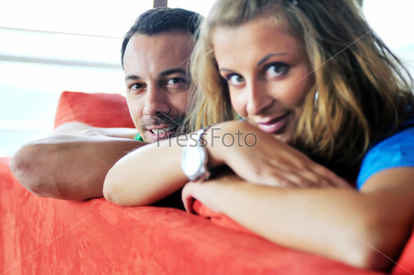 Happy couple relax on red sofa